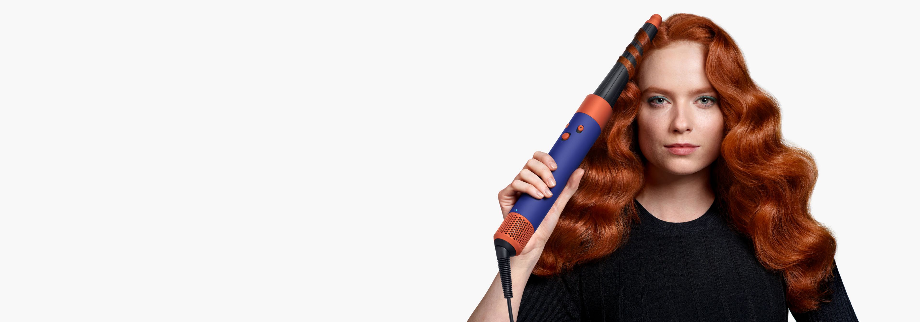 Рыжеволосая модель создаёт локоны с помощью мультистайлера и фена Dyson Airwrap i.d.