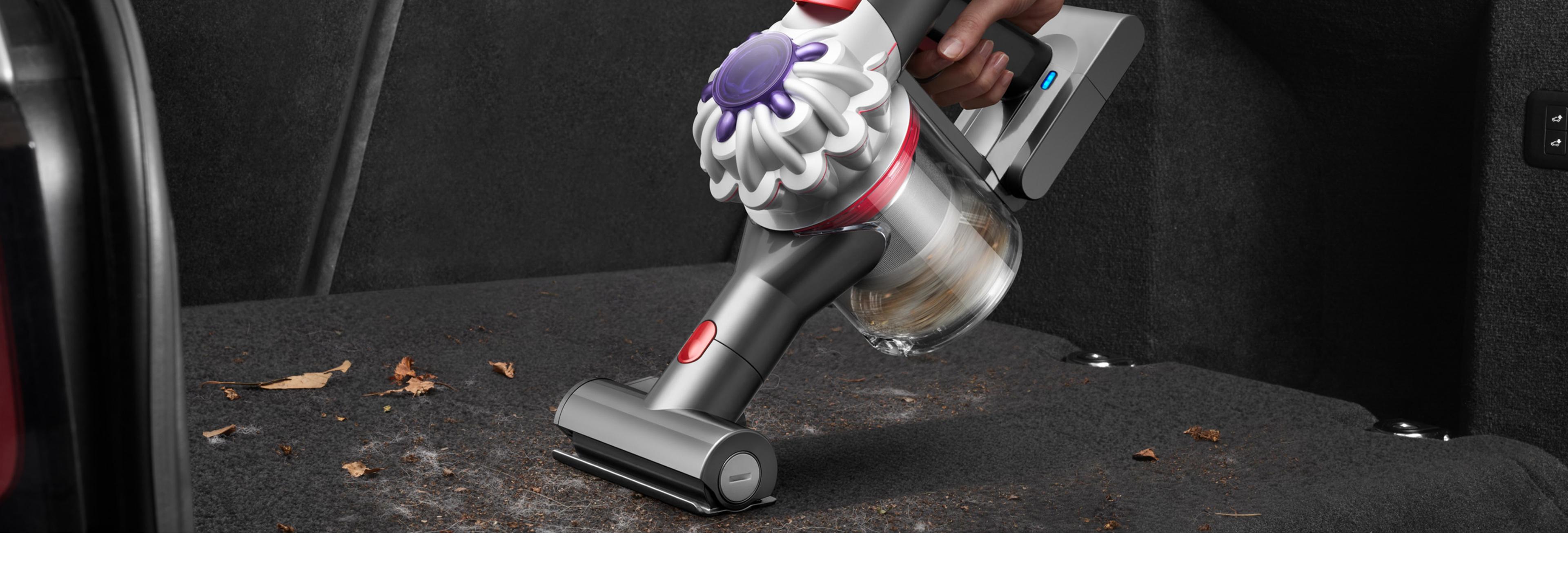 Ручной пылесос Dyson Car+Boat с мини-электрощёткой удаляет шерсть животных и другую грязь с коврового покрытия в багажнике